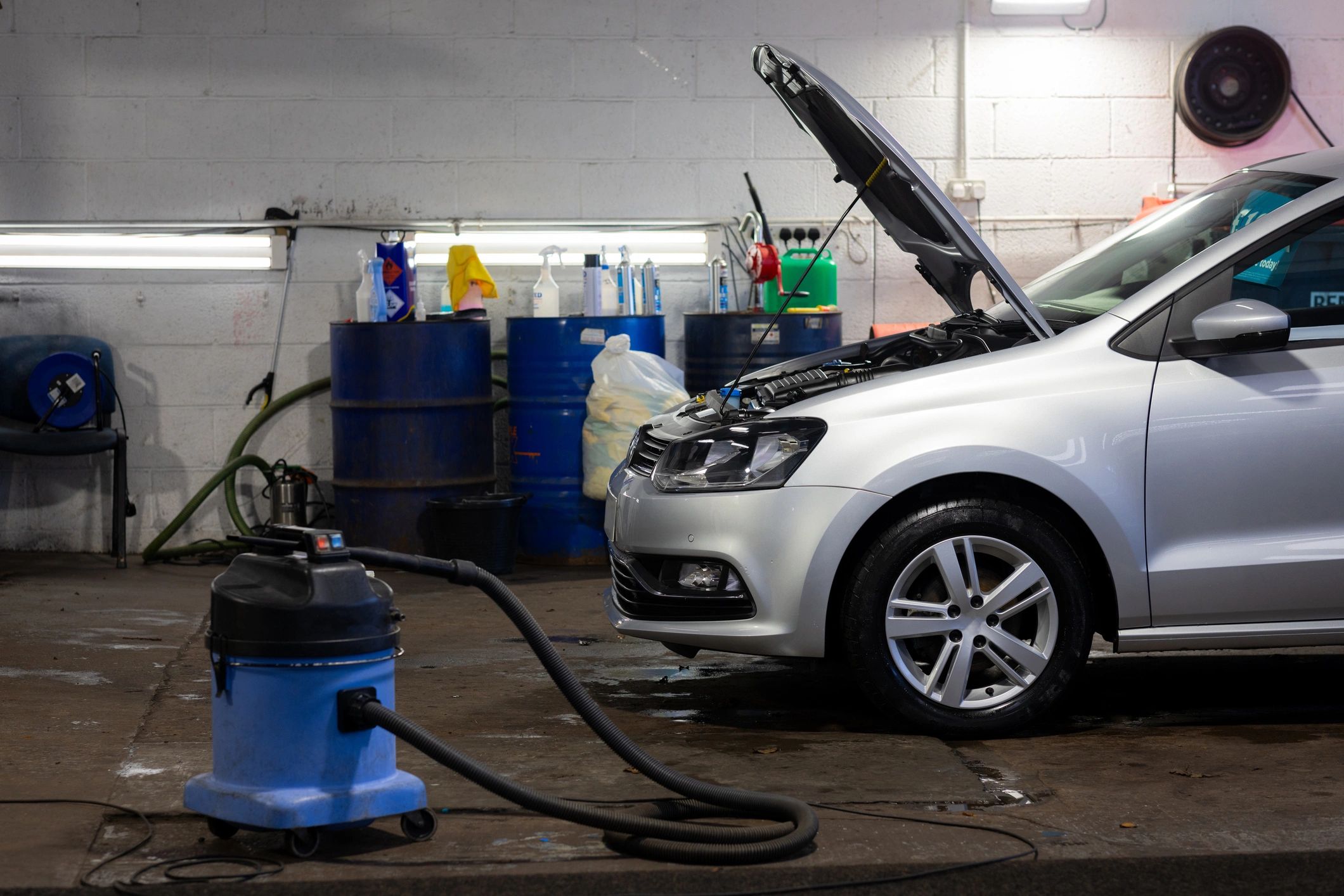 Car being serviced inside a detailing workshop